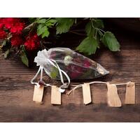 Irish Twins Potpourri sachet in red, green, and brown on a rustic wood surface, with red flowers, green leaves, and small wooden tags nearby Irish Twins Potpourri sachet in red, green, and brown on a rustic wood surface, with red flowers, green leaves, and small wooden tags nearby